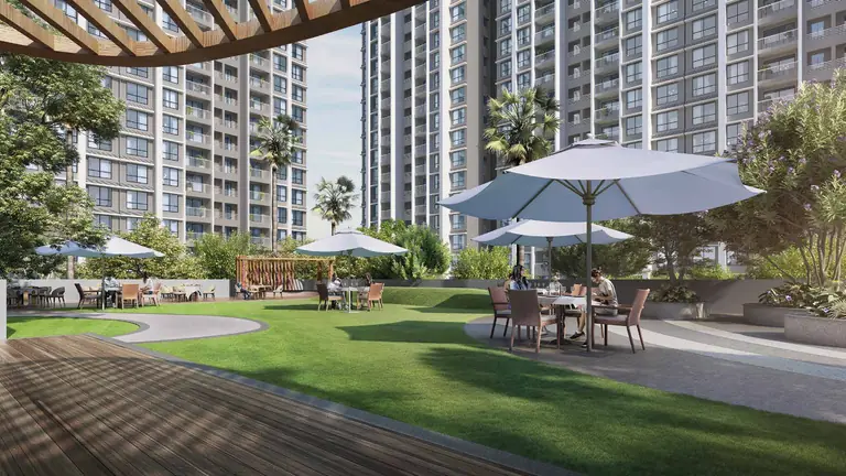 Alfresco dining, umbrellas and open lawn between the towers at Dosti Greenscapes, Hadapsar, Pune