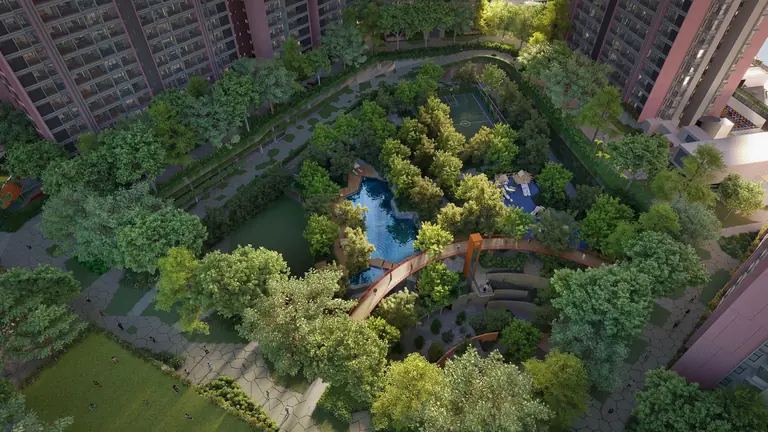 The landscaped grove at Yashada EVO from above, with a water body, walking trails and the bridge between podium decks